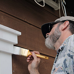 Team member painting window frame