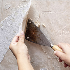 Closeup of person removing wallpaper
