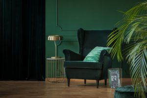 picture of a monochromatic color-coordinated living room with green walls and a green chair