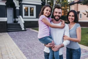 a family standing outside of their new home