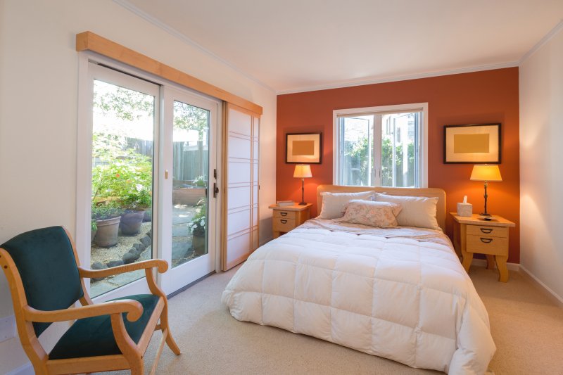 modern bedroom with orange accent wall