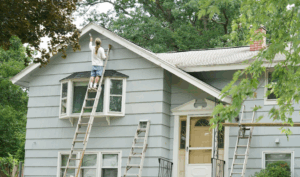 a person painting the exterior of a house