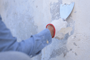 a person scraping away old paint